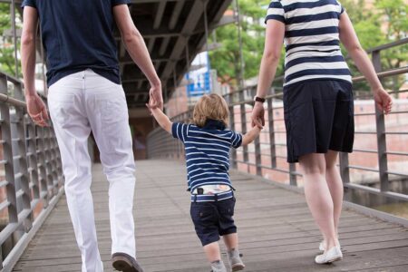 eltern laufend mit kind auf brücke, vom fotograf weg