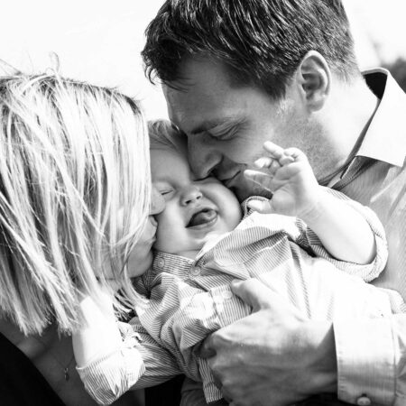 eltern knutschen baby auf backen