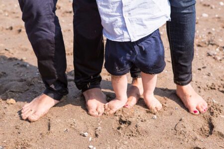füße von eltern und baby am elbstrand