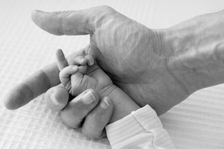 kleine hand vom neugeborenen in der hand vom vater