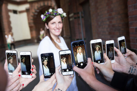 fotoring aus handys im fotomodus vor einer bride-to-be im unscharfen Hintergrund