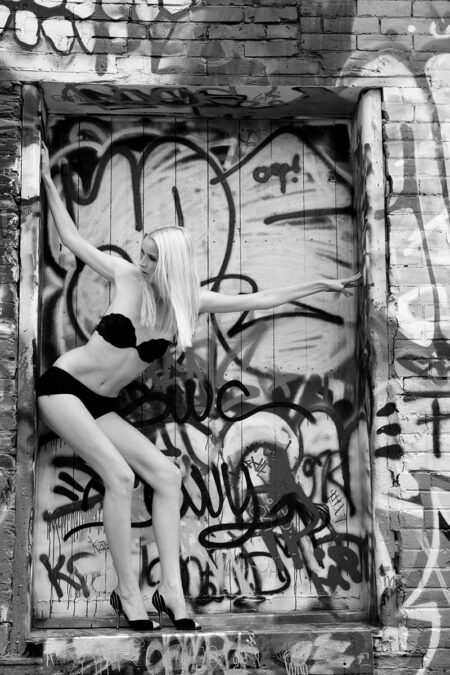 frau steht an laderampe vor vielen graffitis in sexy unterwäsche