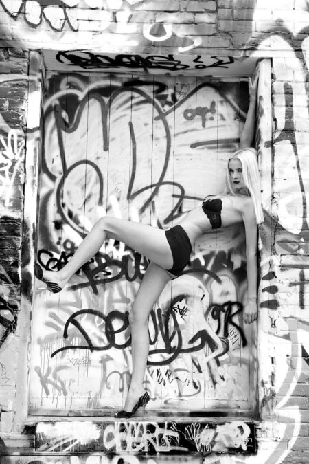 frau lehnt an laderampe vor vielen graffitis in sexy unterwäsche
