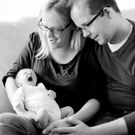 neugeborenes gähnt ganz groß, mama und papa freuen sich