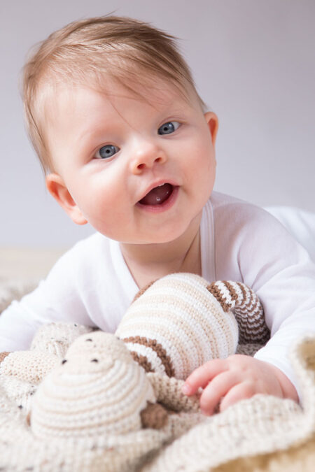 lachendes baby mit kuscheltier
