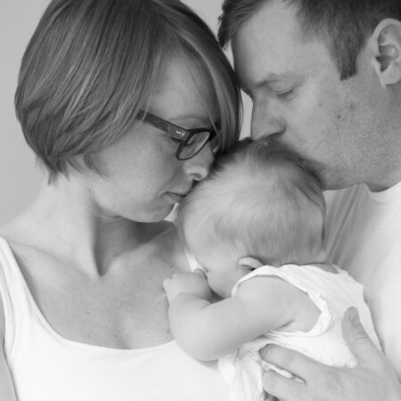 mama und papa küüsen baby auf den kopf