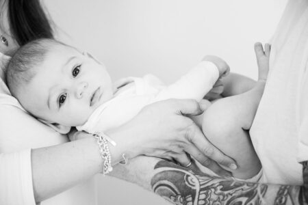 baby zwischen mama und papa auf dem arm