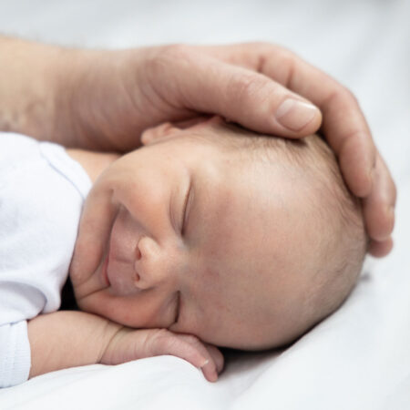 neugeborenen kopf geborgen in hand von papa