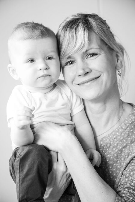 glückliche mama mit baby auf dem arm