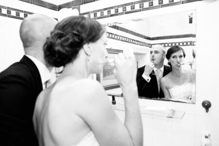 lustiges hochzeitsfoto im badezimmer in den spiegel fotografiert, das brautpaar putzt zähne